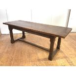 A 17th century style oak refectory table, the solid plank top above an arcaded frieze, on column