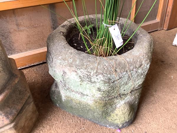 A carved sandstone planter, probably originally a font, of circular form. 36cm by 46cm