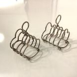 A pair of silver four division toast racks, Birmingham 1962, each with loop handle and raised on