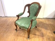 A Victorian rosewood-framed open armchair, with channel-moulded back and green floral upholstery.