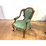 A Victorian rosewood-framed open armchair, with channel-moulded back and green floral upholstery.