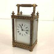 A late 19th century brass carriage clock, of characteristic form, the white enamel dial with Roman