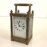 A late 19th century brass carriage clock, of characteristic form, the white enamel dial with Roman