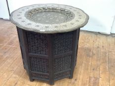 A fine Indian tray top centre table, Jaipur, the engraved brass tray with dished centre and all-over