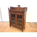 A Glasgow School walnut and inlaid cabinet bookcase, c. 1900, the gallery back incorporating a