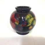 A Moorcroft pottery vase in the Clematis pattern, of globular form, against a blue ground, with