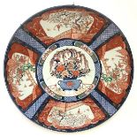 A large Japanese Imari porcelain charger, c. 1900, the well painted with a vase of flowers, the