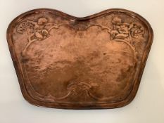 A copper plaque in the Art Nouveau taste, of shaped cartouche form, chased with putti, grapes and