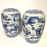 A pair of Chinese blue and white porcelain jars, 20th century, decorated with dragons and flaming