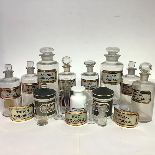 A group of late 19th/early 20th century clear glass pharmacy jars each with red and gilt label