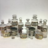 A group of late 19th/early 20th century clear glass pharmacy jars each with red and gilt label