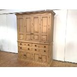 A pine 19th century style housekeeper's cupboard, the projecting cornice above a pair of hinged