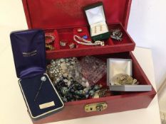 A jewellery box containing a quantity of costume jewellery including rings, brooches, necklaces, a