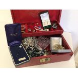 A jewellery box containing a quantity of costume jewellery including rings, brooches, necklaces, a