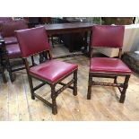 A pair of oak side chairs with maroon leather back and seats, on turned front supports with turned