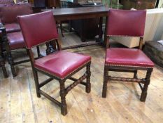 A pair of oak side chairs with maroon leather back and seats, on turned front supports with turned