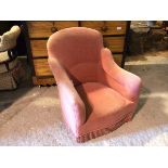 A bedroom tub chair in mauve upholstery with tassel fringed apron (76cm x 65cm x 66cm)