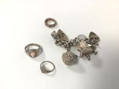 A silver charm bracelet, with most charms marked 'silver' and two silver rings and another (charm