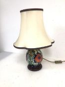 A Moorcroft table lamp of baluster form with poppy pattern on circular base, complete with shade (