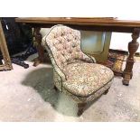 A late Victorian nursing chair in floral upholstery, on turned front supports, on castors (73cm x