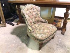 A late Victorian nursing chair in floral upholstery, on turned front supports, on castors (73cm x