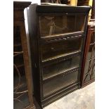 A 1930s/40s oak compartmental bookcase, fitted four shelves, each with sprung drop front glazed door