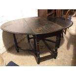 An early 20thc ebonised gateleg table with oval top on turned supports united by stretchers, on pear