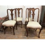 A set of four mahogany Edwardian side chairs with inlaid pierced splats, with upholstered seats on