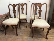 A set of four mahogany Edwardian side chairs with inlaid pierced splats, with upholstered seats on
