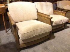 A lady and gentleman's Ercol armchair set, both with caned sides and sand corduroy upholstery,