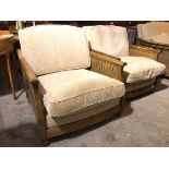 A lady and gentleman's Ercol armchair set, both with caned sides and sand corduroy upholstery,