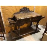 A 1920s/30s oak hall table, with foliate crest above a rectangular top with moulded edge, stick