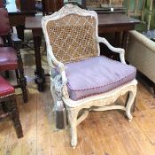 A Louis XV style fauteuil with carved crest rail over a caned back, the arms with acanthus leaves to