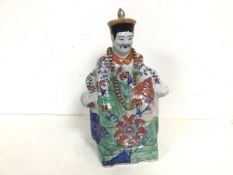 An early 20thc Chinese ceramic sculpture of a Seated Noble, with foliate decoration, and a blue seal