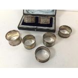 A collection of silver napkin rings including a pair of Edwardian Sheffield silver octagonal