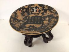 A modern Chinese shallow bowl depicting figures and characters, black ground, red stamp to base with