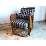 A stylish Ralph Lauren rattan lounge chair with striped upholstered back and seat cushion in navy