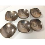 A set of six Indian white metal dishes, each with a George V one rupee coin to base of well, with