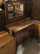 An Edwardian dressing table, the bevelled mirror with domed top, supports lacking finials, fitted