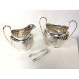 A 1920s Birmingham silver milk jug and a two handled sugar bowl with sugar nips (combined: 383.