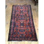 A Hamadan rug, with foliate design within three borders with scrolling leaf and flower design, red