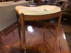 A mid century teak footstool, with upholstered top (a/f) on dished front and back apron, on turned