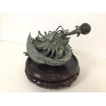 A Chinese cast metal Dragon and Pearl (20cm x 20cm x 25cm) on wooden circular base