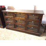 A modern shopkeeper's haberdashery cabinet, the moulded top above nine glazed drawers, each with