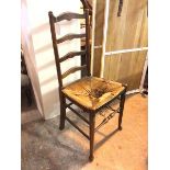 A 19thc ladderback chair with rush seat (a/f) on front turned tapering supports united by stretchers