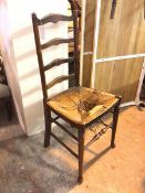 A 19thc ladderback chair with rush seat (a/f) on front turned tapering supports united by stretchers