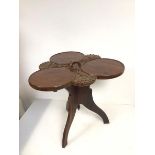 A carved Indian occasional table, the central handle above a three part circular table top divided