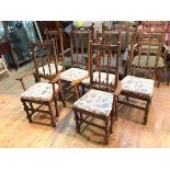 A set of six Ercol elm dining chairs, the architectural top rail on a spindle back, with upholstered