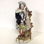 A 19thc Staffordshire figure of a Highlander leaning on a Tree (41cm)