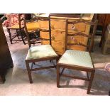 A pair of early 20thc side chairs, with pierced yoke ladder backs and upholstered drop in seats,
